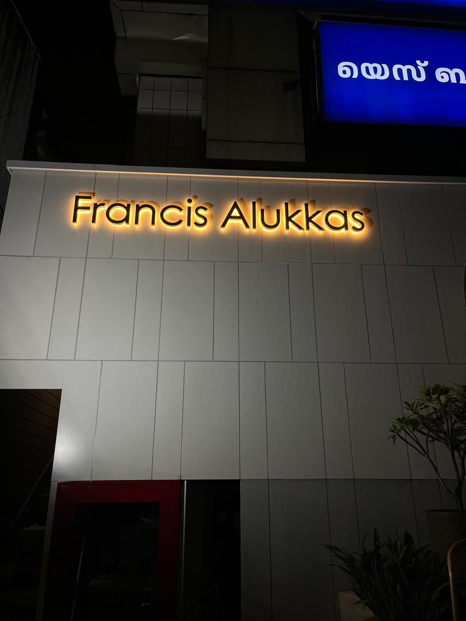 Francis Alukkas facade with warm halo-lit signage